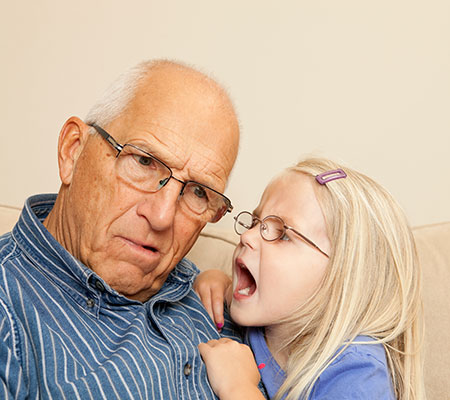 Picture of young girl yelling into older man's ear