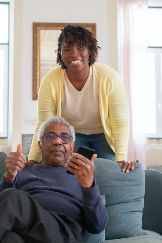 Woman standing behind person on couch courtesy Kampus Production on Pexels