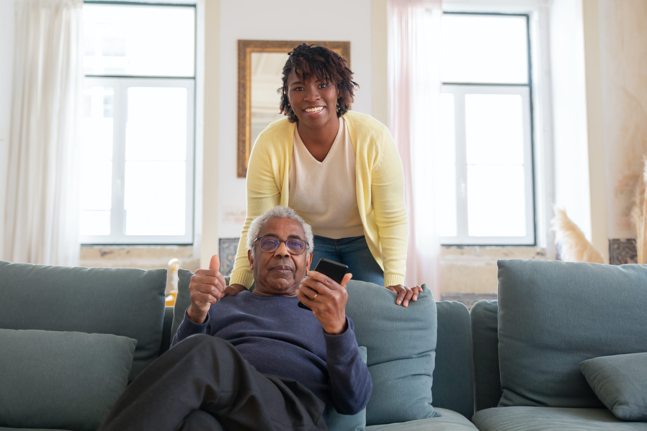 Woman standing behind person on couch courtesy Kampus Production on Pexels