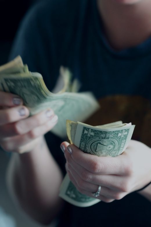 Photo of person counting cash by Sharon McCutcheon on Unsplash