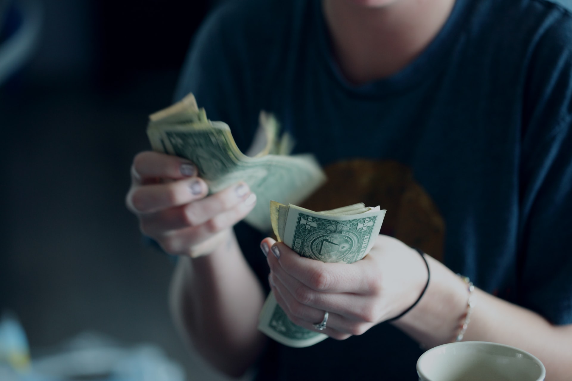 Photo of person counting cash by Sharon McCutcheon on Unsplash