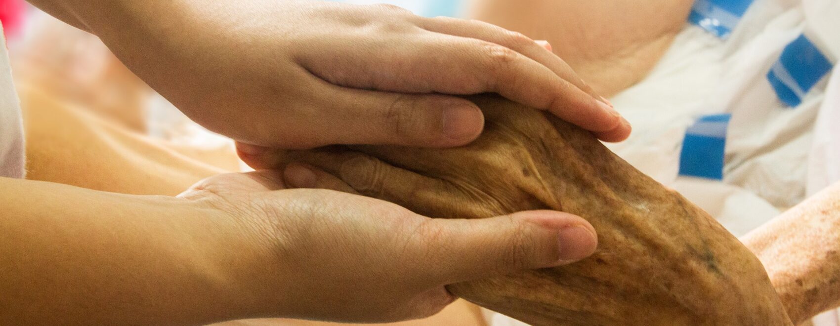 young hands holding an older hand